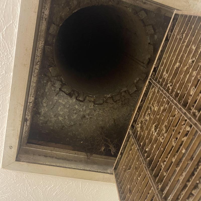 Air vent and duct opening with dirty grille and cobwebs