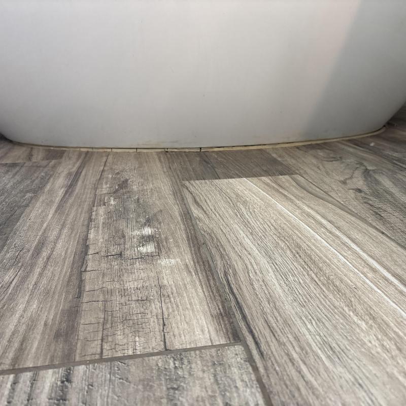Freestanding bathtub base with old caulking removed