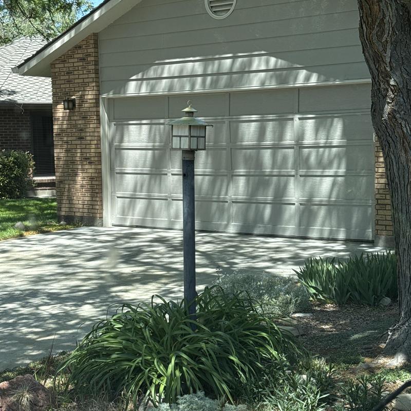 Garage door exterior with lamp post and landscaping