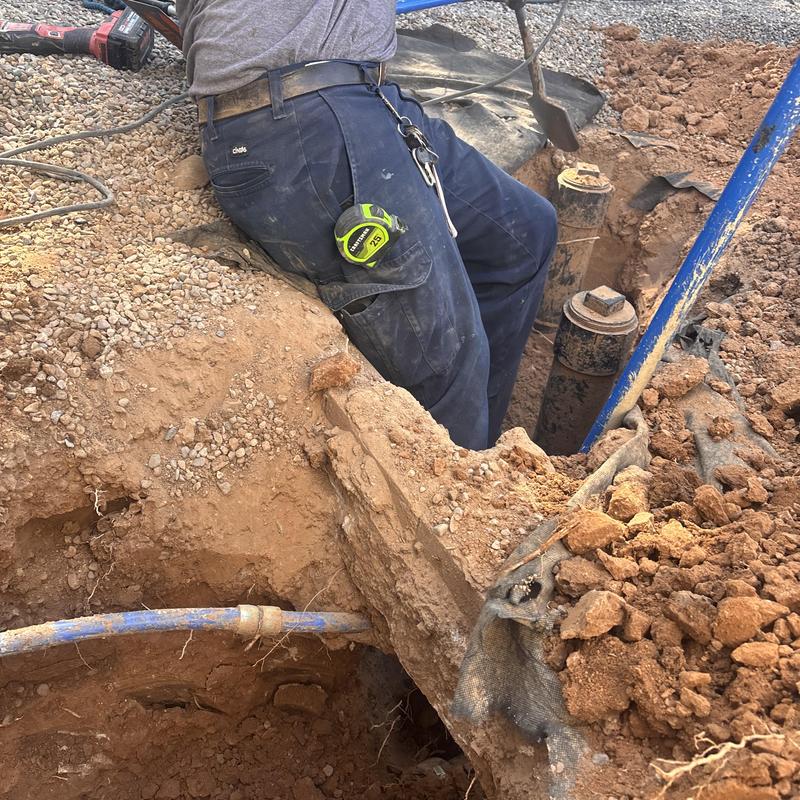 Main sewer line and pipe excavation in dirt trench
