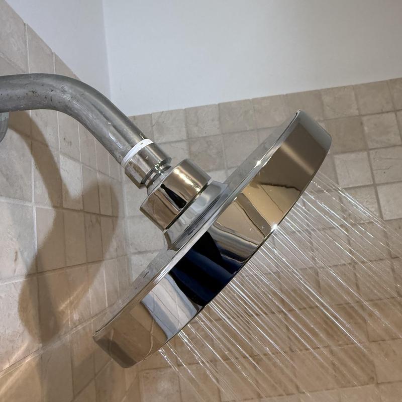 Shower head with water flow in tiled shower wall