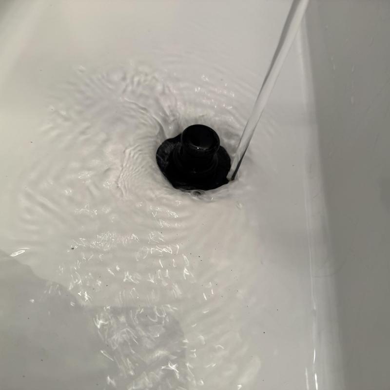 Basin drain clearing with flowing water in sink
