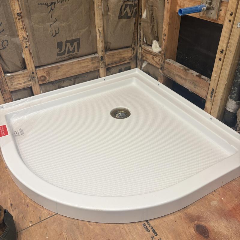 Shower pan installed on wooden subfloor framing