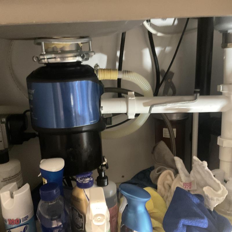 Garbage disposal installation under kitchen sink with supplies