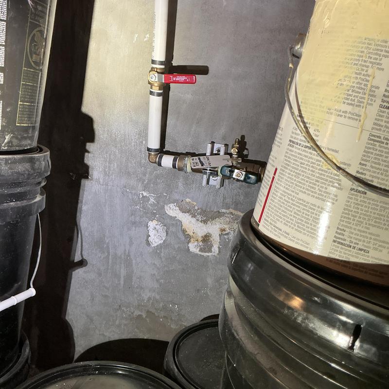 Water shutoff valve and pipes in basement wall