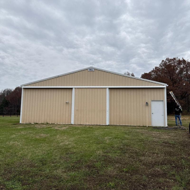 Metal building exterior with roofing inspection
