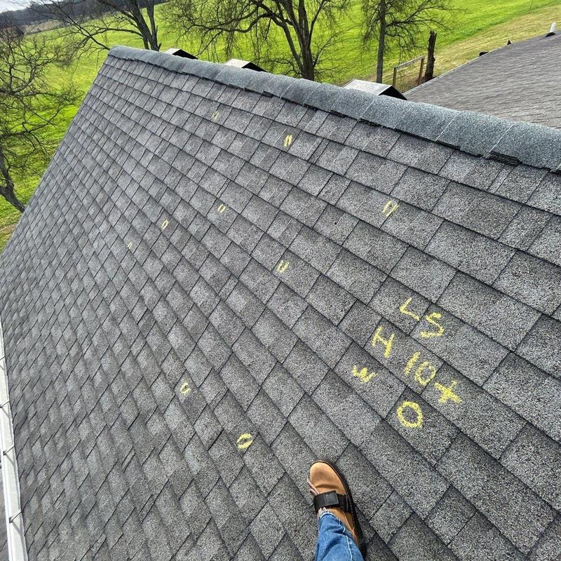 Asphalt shingles with hail damage markings on roof