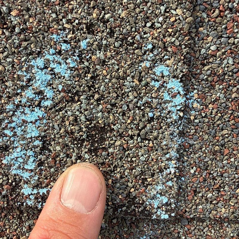 Shingle hail impact marked with blue chalk and finger