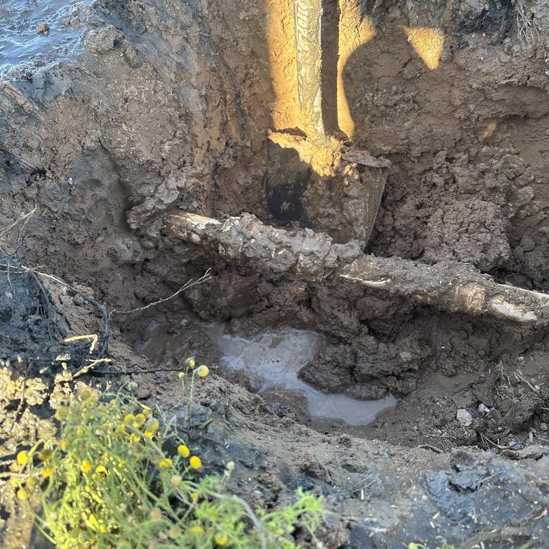 Outdoor water pipe excavation with shovel in mud