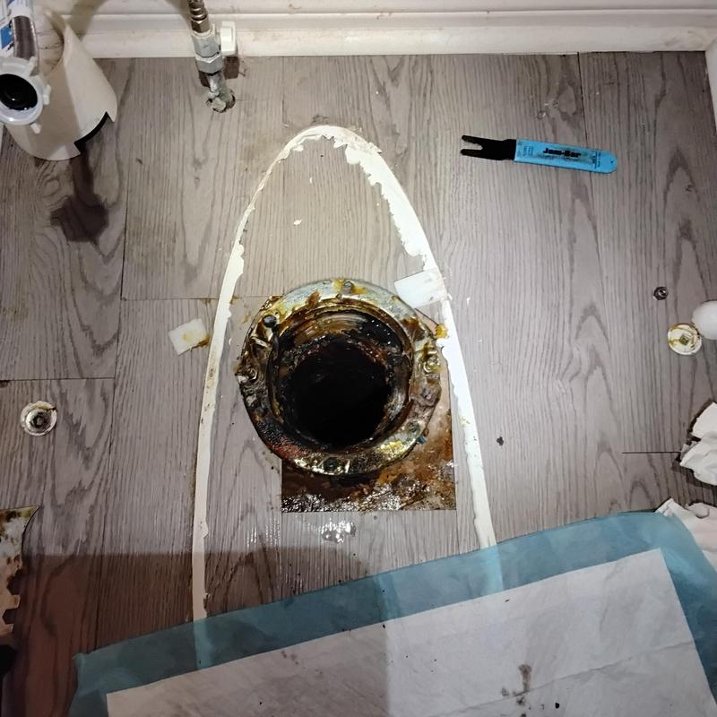 Cast iron toilet flange with corrosion on floor
