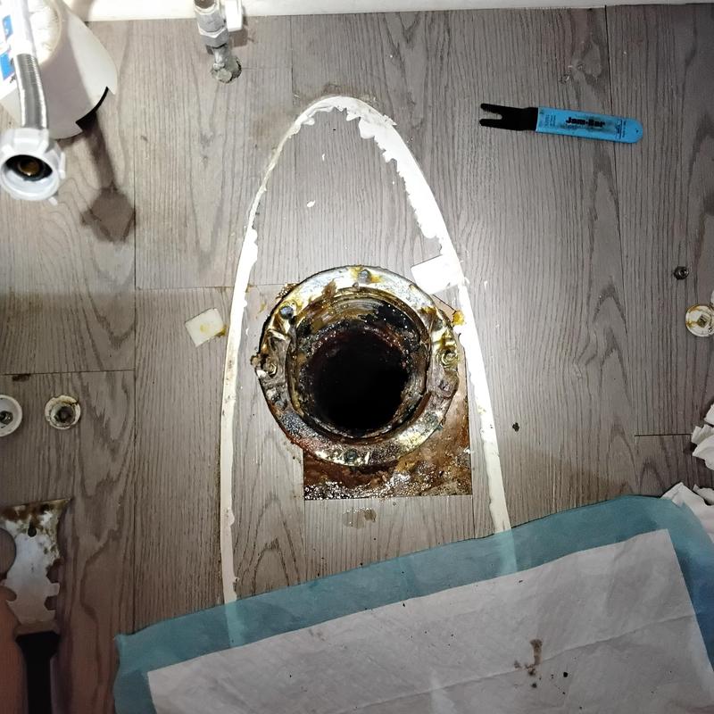 Cast iron toilet flange with corrosion and debris