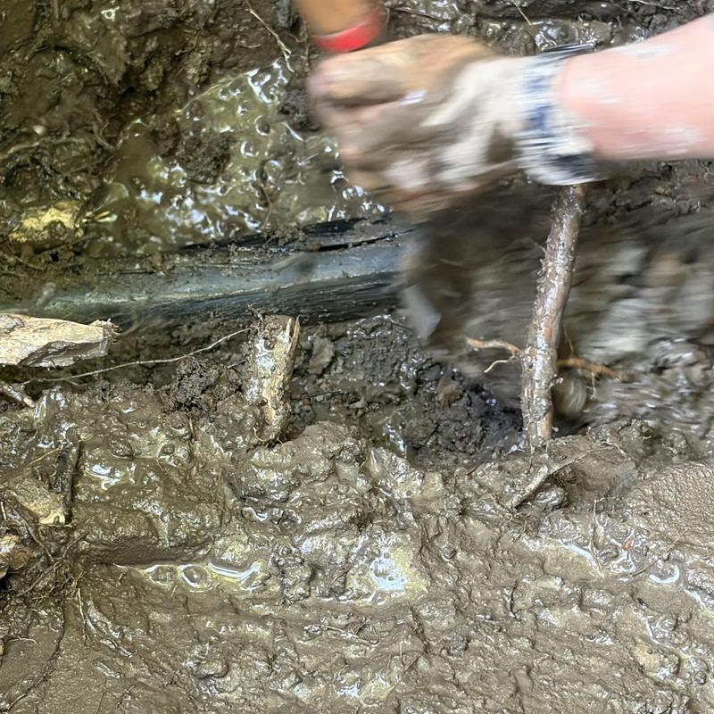 Water supply pipe exposed in muddy soil excavation site Water supply pipe exposed in muddy soil excavation site