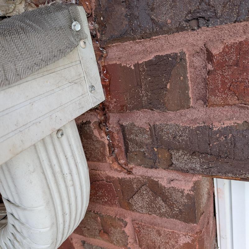 Window roof flashing with rusted sealant on brick wall Window roof flashing with rusted sealant on brick wall