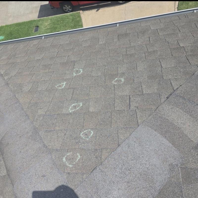 Architectural shingles with hail damage markings on roof