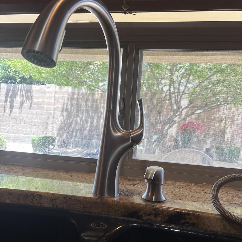 Kitchen faucet with soap dispenser installed on granite countertop