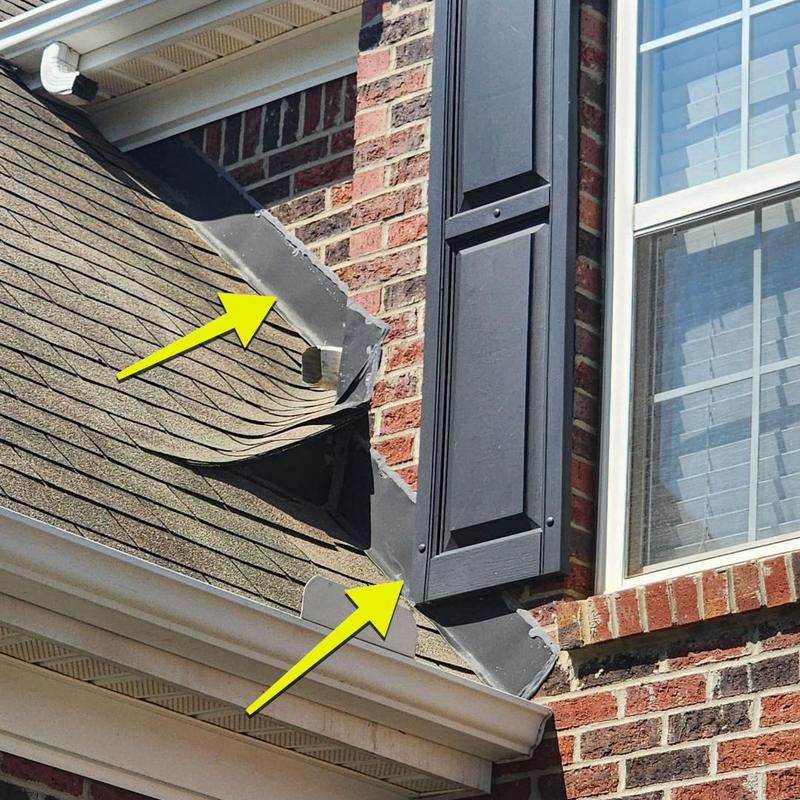 Roof flashing with sealant around brick wall and shingles