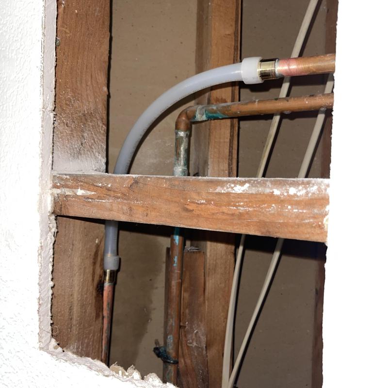 Copper plumbing and PEX piping installation inside wall cavity