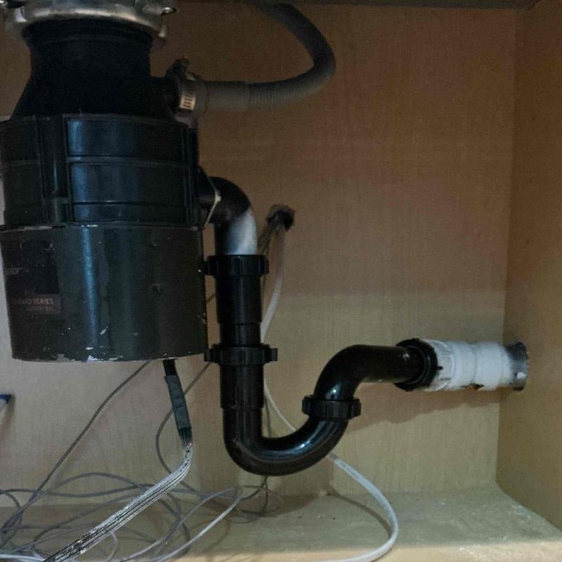 Garbage disposal with connected drain pipes under sink