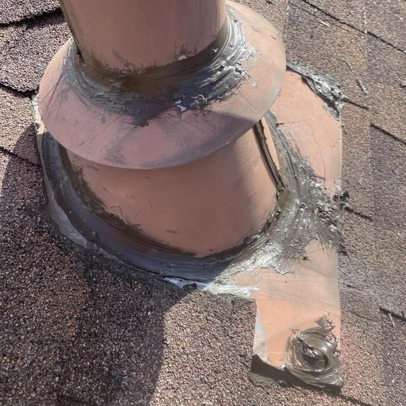 Roof vent flashing with sealant repairs on shingles