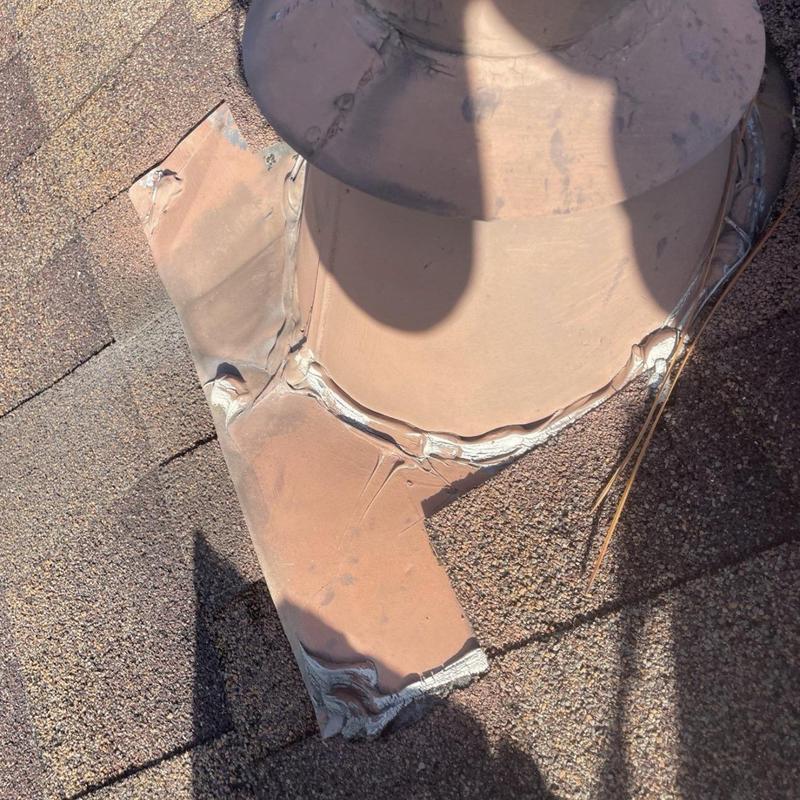 Roof vent flashing with sealant repair on shingle roof