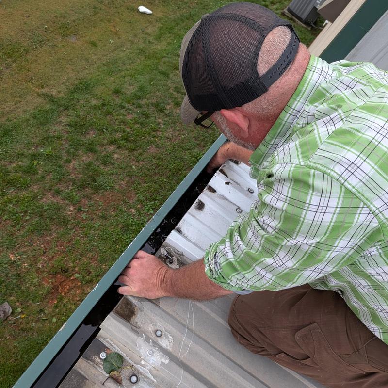 Gutter cleaning on commercial building roof edge Gutter cleaning on commercial building roof edge