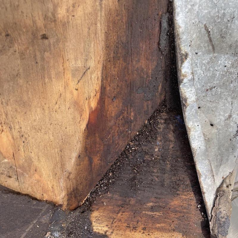 Chimney wood decking with water damage and debris buildup