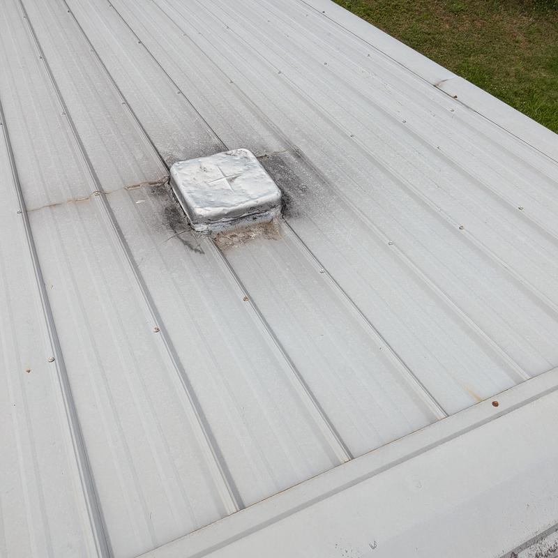 Metal roof vent with damaged and rusted sealant Metal roof vent with damaged and rusted sealant