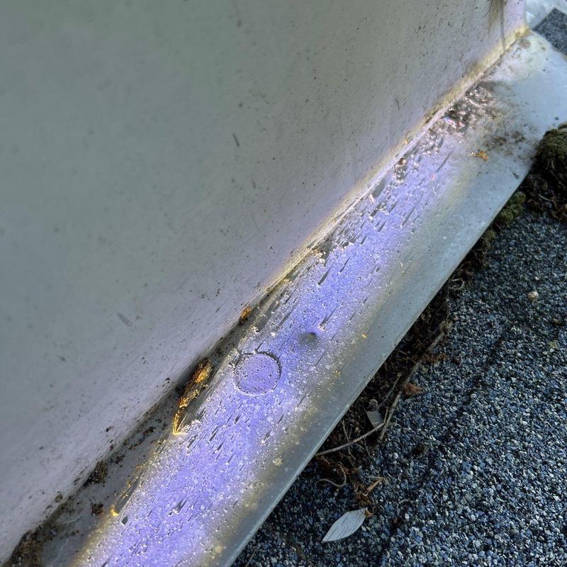 Metal flashing with hail impact dents and debris buildup