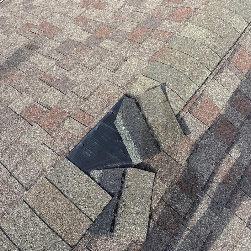 Roof shingles with hail damage and flashing exposed