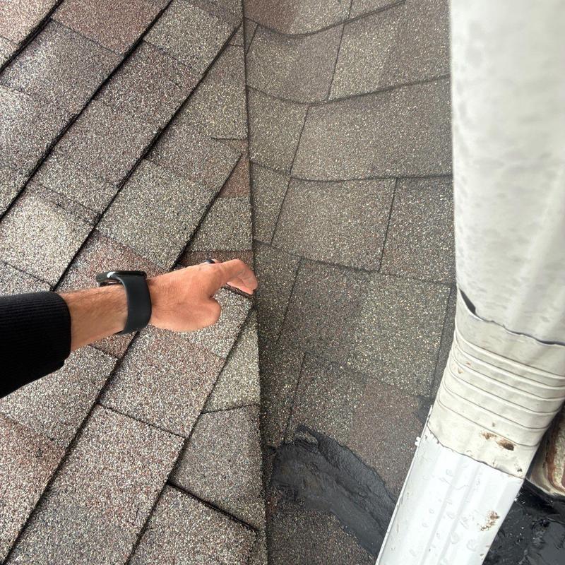 Roof shingles with hail damage near flashing system