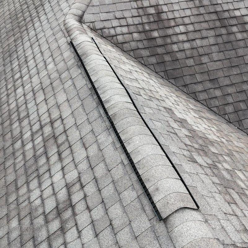 Asphalt shingle roof with ridge vent and hail damage