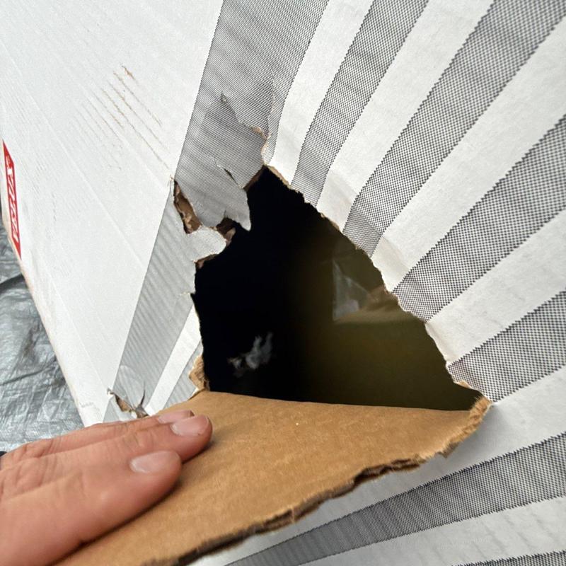 Packaging cardboard with torn hole from damage