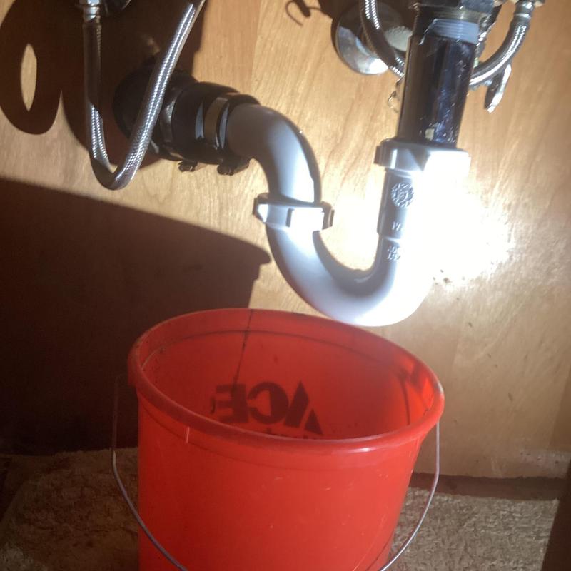 Newport trap under bathroom sink with leak bucket