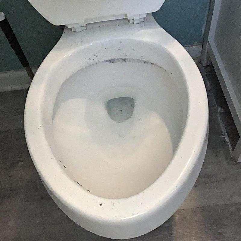 Toilet bowl with minor debris and stains inside