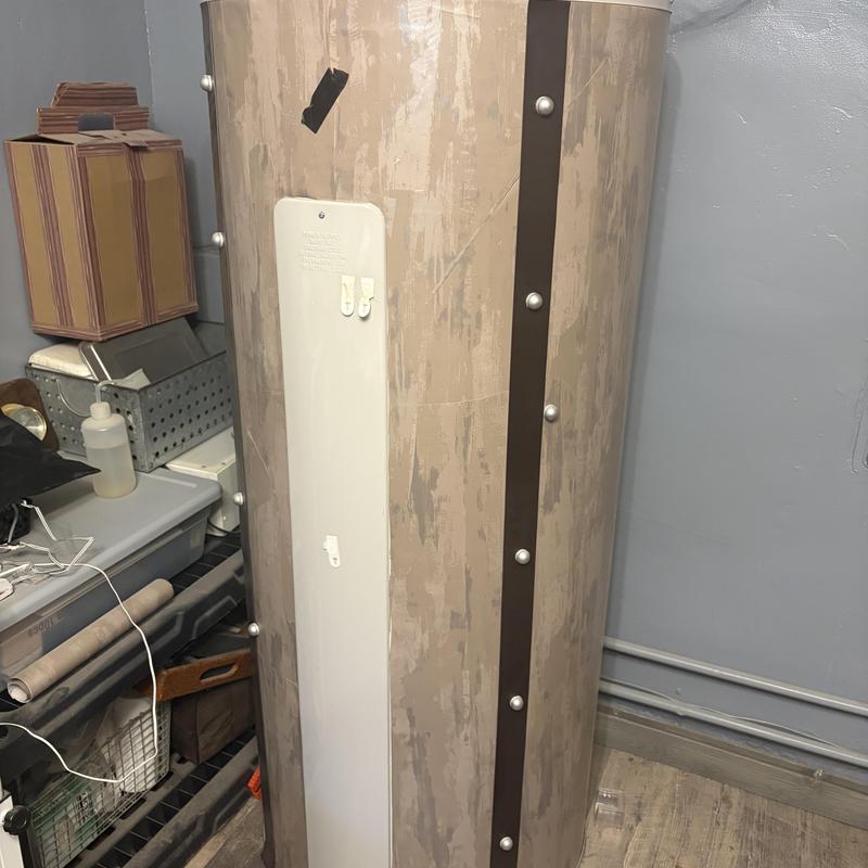 Water heater tank with old insulation in utility room