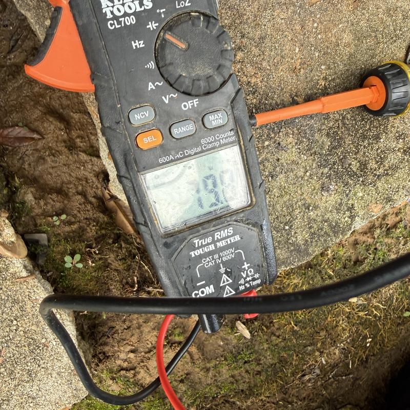 Clamp meter measuring HVAC system current outdoors Clamp meter measuring HVAC system current outdoors