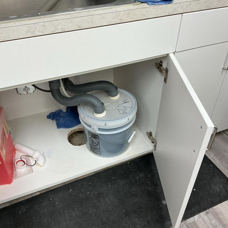 Sump pump system with dual drainage hoses under sink