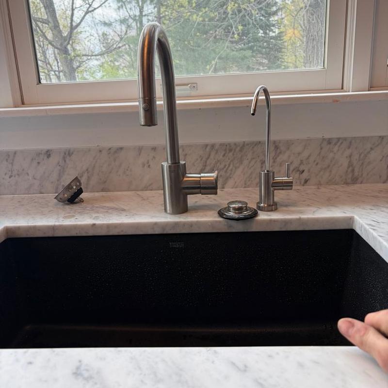 Kitchen faucet and water filter faucet on marble countertop