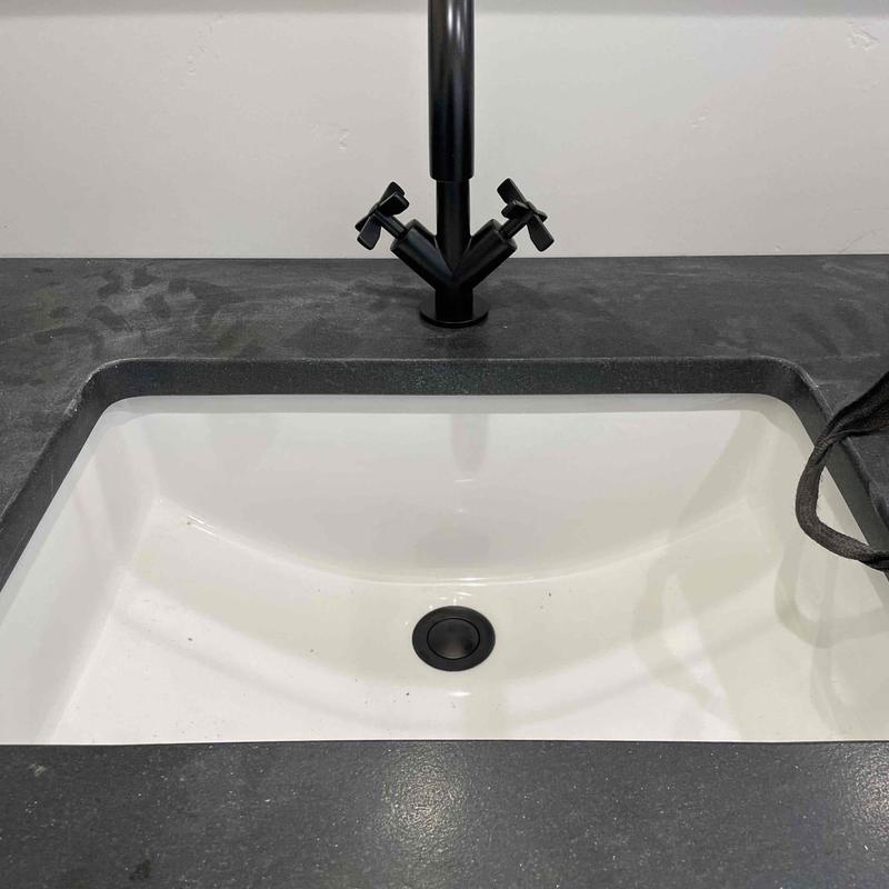 Matte black faucet and rectangular sink on gray countertop