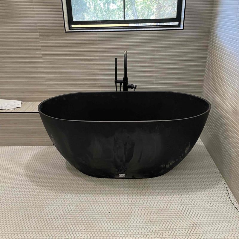 Freestanding black bathtub with matte black faucet
