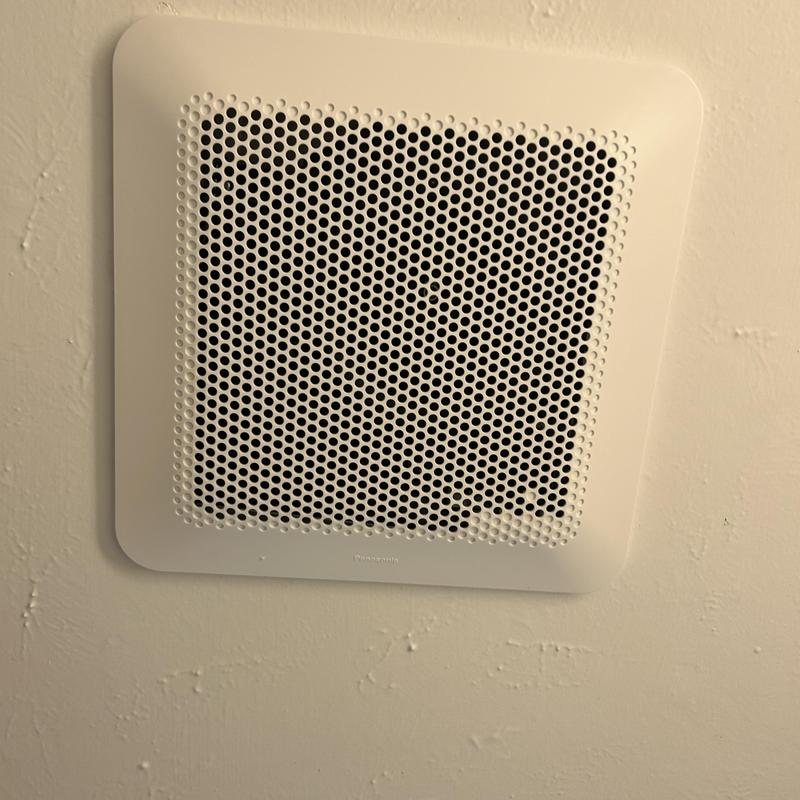 Bathroom exhaust fan with perforated grille installed
