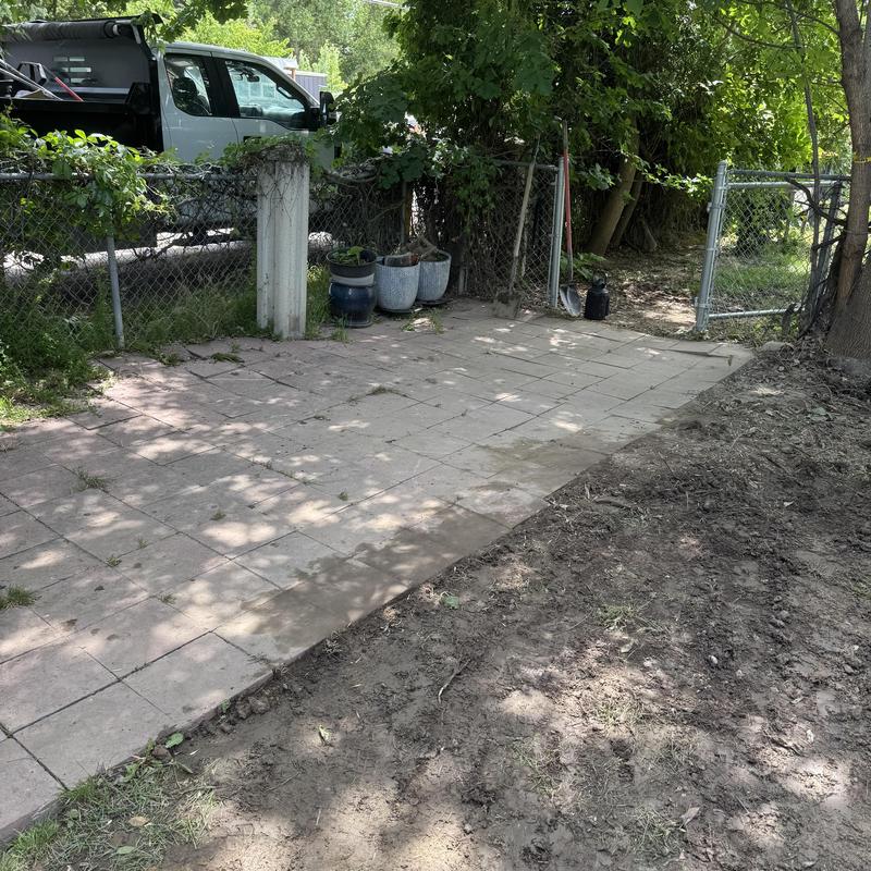 Backfilled area with tiled patio and cleared yard space
