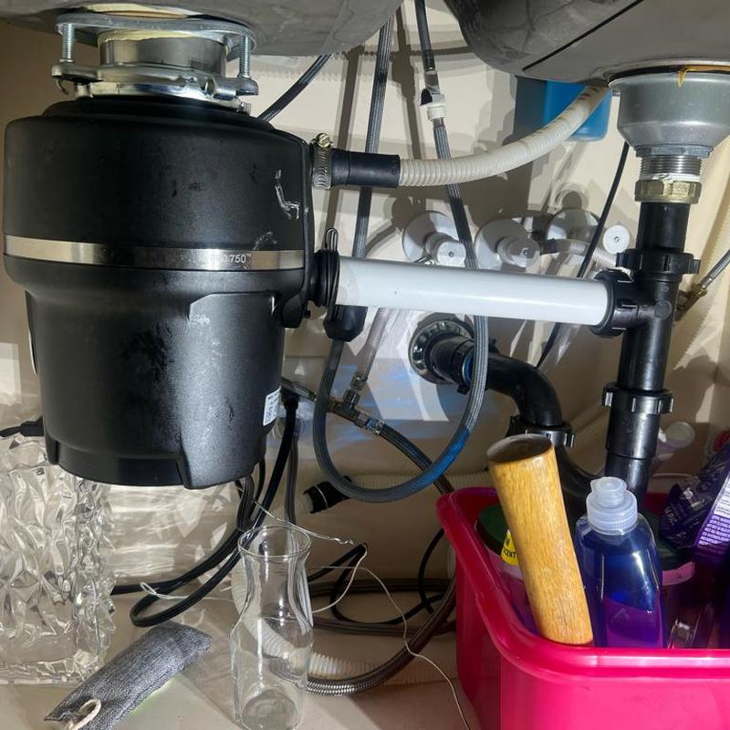Kitchen sink garbage disposal and drain pipes under sink