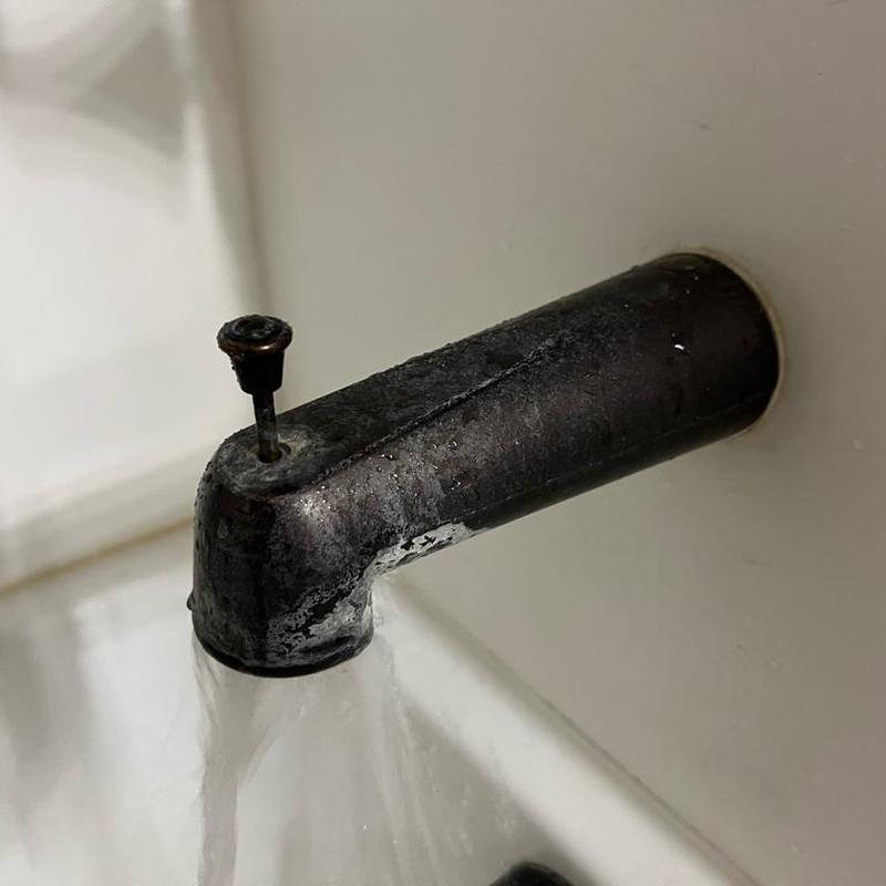 Bathtub spout leaking water, corrosion visible Bathtub spout leaking water, corrosion visible