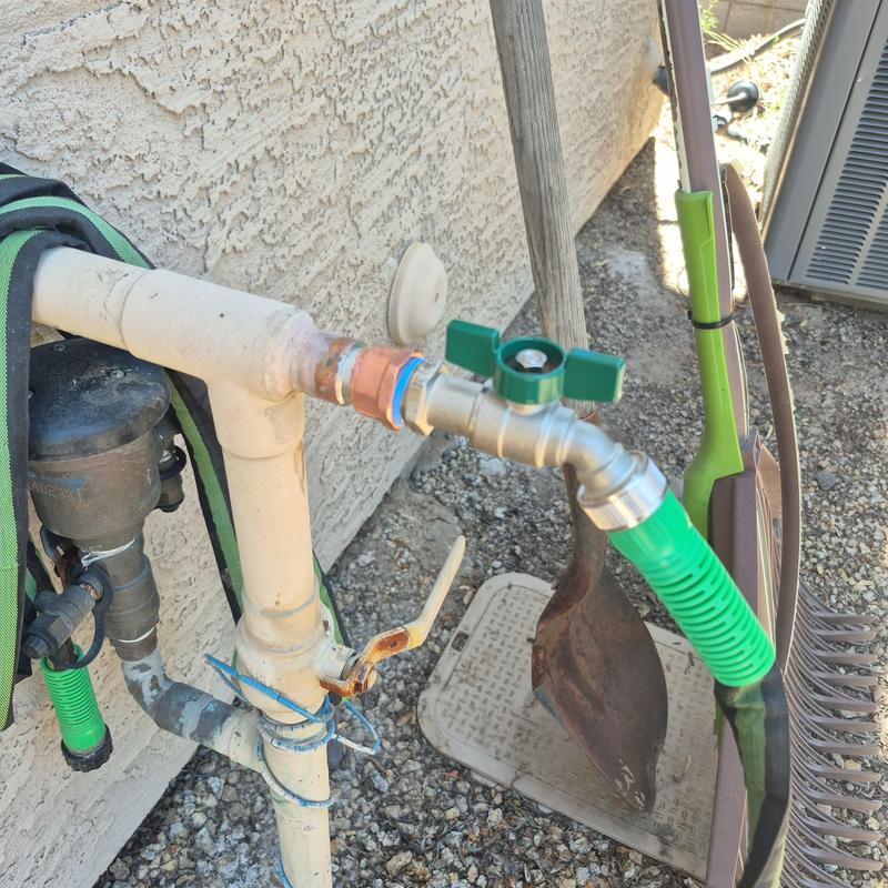 Outdoor hose bib with newly installed valve and green hose