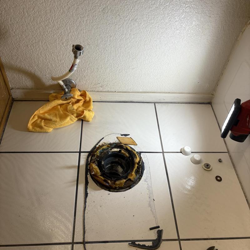 Toilet flange and water supply valve installation prep on tile floor
