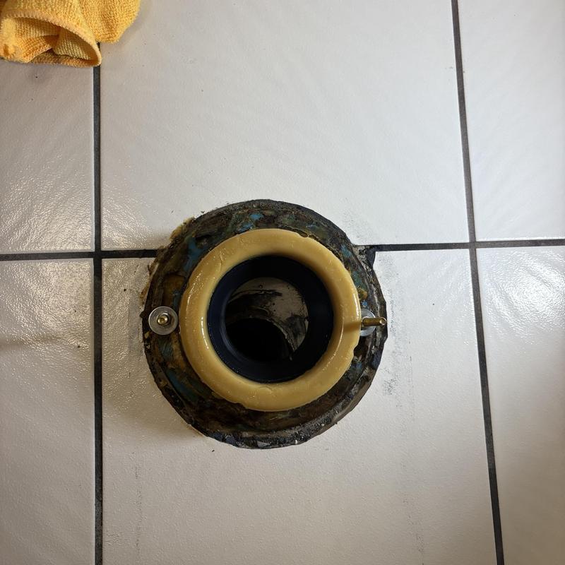 Toilet flange with wax ring on tiled floor