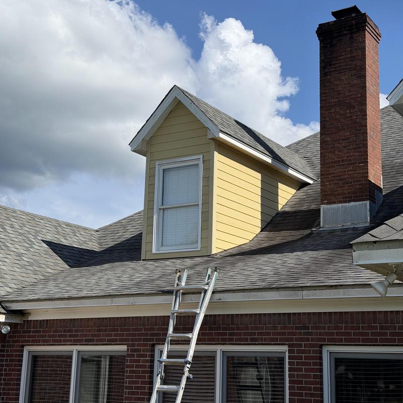 Dormer siding installation with flashing and ladder