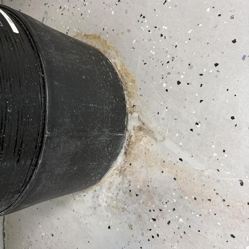 Iron filter leaking onto garage floor with corrosion stains