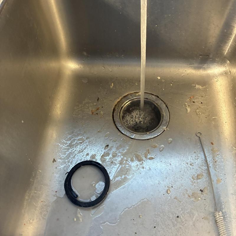Kitchen sink drain with flowing water and cleaning tools